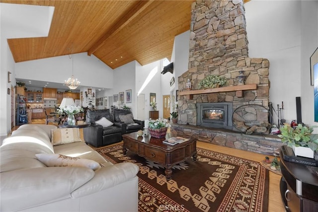 living area featuring a notable chandelier, a fireplace, light wood-style flooring, wood ceiling, and high vaulted ceiling