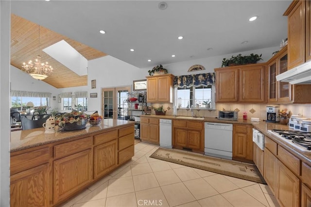 kitchen featuring a sink, french doors, dishwasher, brown cabinetry, and glass insert cabinets