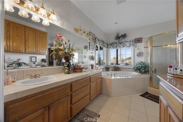 bathroom with a stall shower, tile patterned flooring, a sink, and a bath