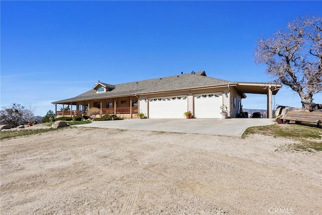 view of front of house with an attached garage, a porch, and concrete driveway