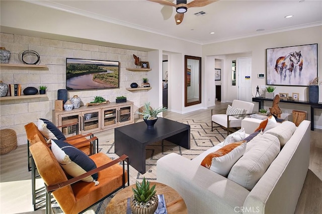 living area with ornamental molding, light wood-type flooring, visible vents, and recessed lighting