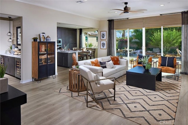 living room featuring ceiling fan, recessed lighting, visible vents, light wood finished floors, and crown molding