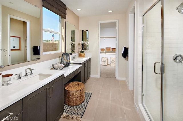 bathroom with double vanity, recessed lighting, a sink, and a shower stall