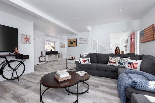 living room with beamed ceiling, light wood-type flooring, recessed lighting, and stairs