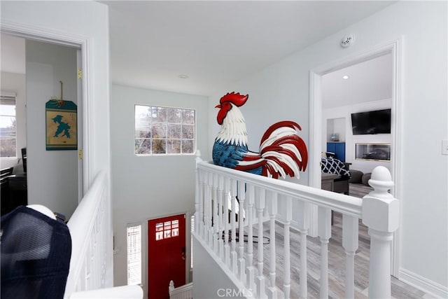 hall featuring an upstairs landing and wood finished floors