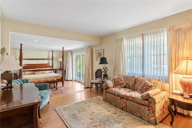 living area with light wood-type flooring and crown molding