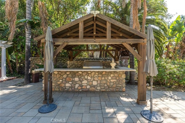 view of patio / terrace with exterior bar, a grill, exterior kitchen, and a gazebo