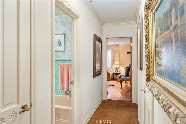 hall with carpet floors, crown molding, and wallpapered walls