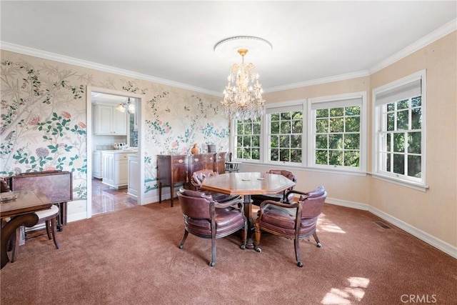 dining area with a chandelier, light colored carpet, crown molding, baseboards, and wallpapered walls