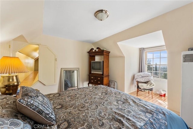 bedroom featuring vaulted ceiling and wood finished floors