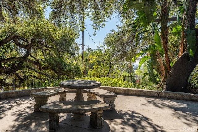 view of community featuring fence and a patio