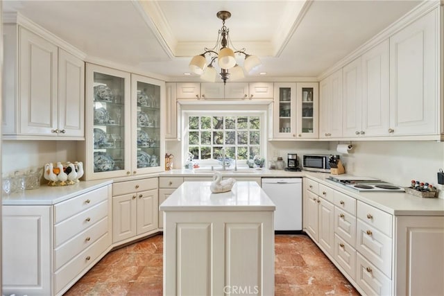 kitchen with white appliances, white cabinets, light countertops, a center island, and glass insert cabinets