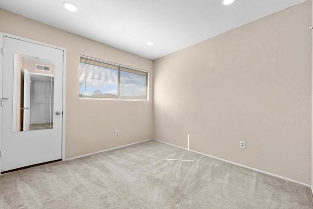 carpeted empty room featuring visible vents and recessed lighting