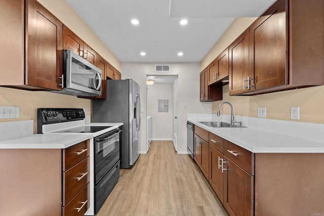 kitchen featuring recessed lighting, stainless steel appliances, a sink, visible vents, and light wood finished floors