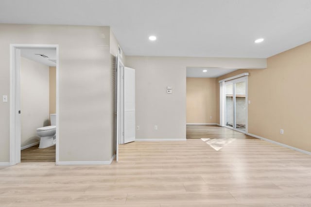 empty room with light wood finished floors, baseboards, and recessed lighting