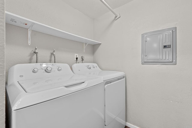 clothes washing area with laundry area, electric panel, and washer and dryer