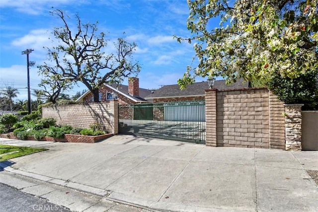 view of front of property featuring stone siding, a gate, and fence