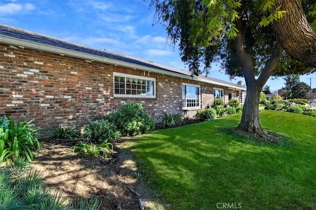 ranch-style home with brick siding and a front yard