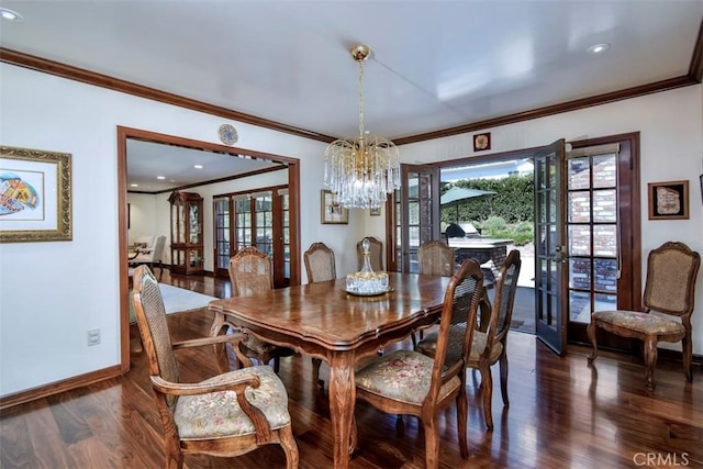 dining space featuring french doors, dark wood-style flooring, ornamental molding, a chandelier, and baseboards