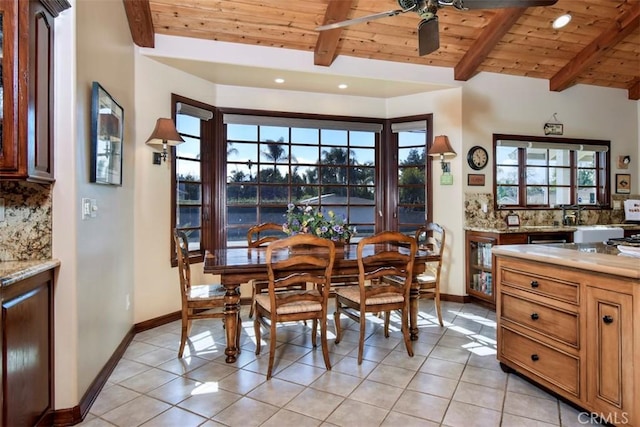 dining space with vaulted ceiling with beams, wood ceiling, ceiling fan, and light tile patterned floors