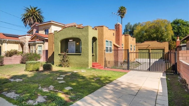 mediterranean / spanish-style home with a front yard, a gate, fence, and stucco siding