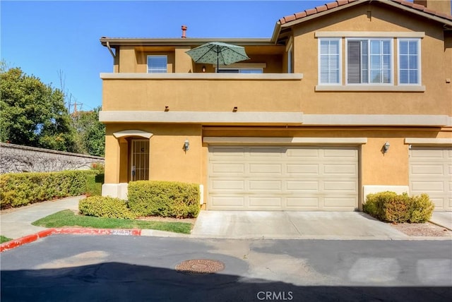 view of front of property featuring a garage, driveway, and stucco siding