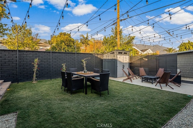 view of yard featuring a storage unit, a patio area, a fenced backyard, and an outdoor structure