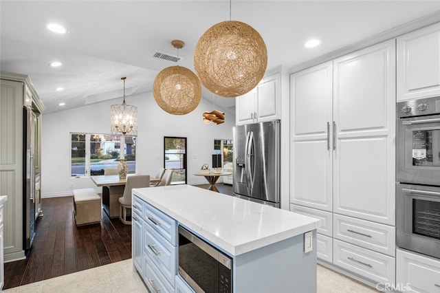 kitchen featuring light stone counters, stainless steel appliances, visible vents, white cabinets, and wood finished floors