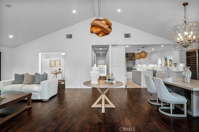 living area featuring high vaulted ceiling, light wood-style floors, visible vents, and a notable chandelier