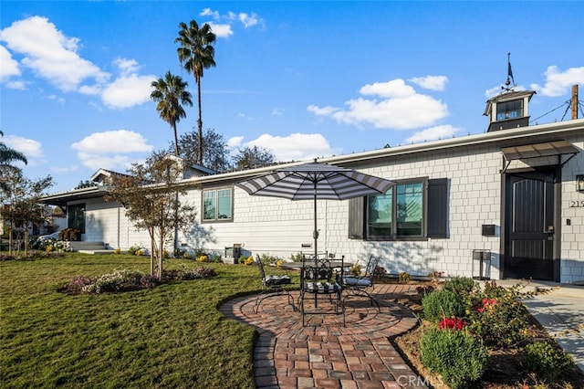 rear view of property featuring a yard and a patio