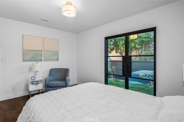 bedroom featuring baseboards, visible vents, and dark wood finished floors