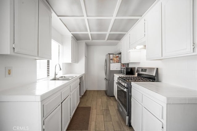 1787 N Ella Mae Ln, San Jacinto, CA 92583 - kitchen with light wood-style flooring, a sink, under cabinet range hood, appliances with stainless steel finishes, and white cabinets
