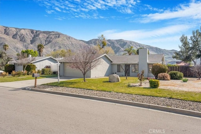 1787 N Ella Mae Ln, San Jacinto, CA 92583 - view of front of home featuring fence, driveway, an attached garage, a front lawn, and a mountain view