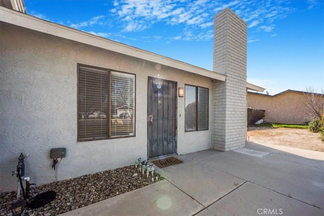1787 N Ella Mae Ln, San Jacinto, CA 92583 - entrance to property with stucco siding and a chimney