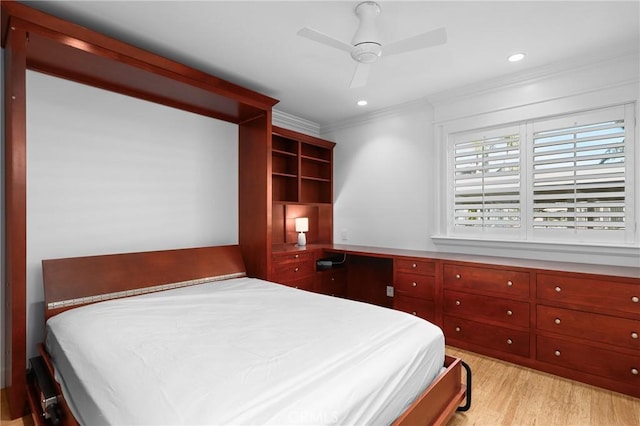 bedroom with ornamental molding, built in study area, light wood-style flooring, and recessed lighting