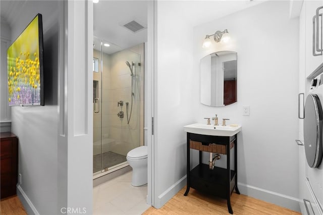 full bathroom with visible vents, toilet, a stall shower, wood finished floors, and baseboards