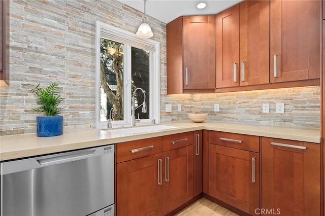 kitchen featuring tasteful backsplash, light countertops, dishwasher, and a sink