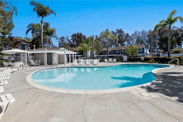 community pool featuring fence and a patio