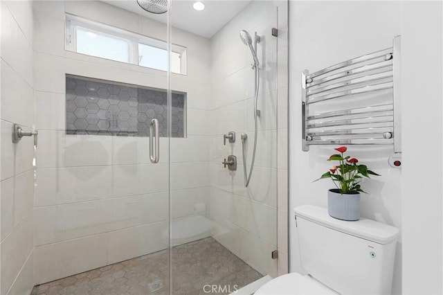 bathroom featuring toilet, a stall shower, radiator heating unit, and visible vents