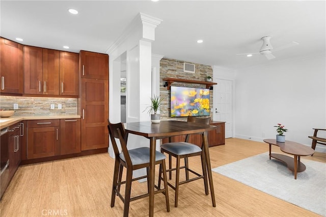 kitchen featuring light wood finished floors, tasteful backsplash, ornamental molding, and light countertops