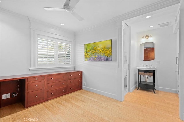 office space with light wood-style flooring, ornamental molding, ceiling fan, and baseboards