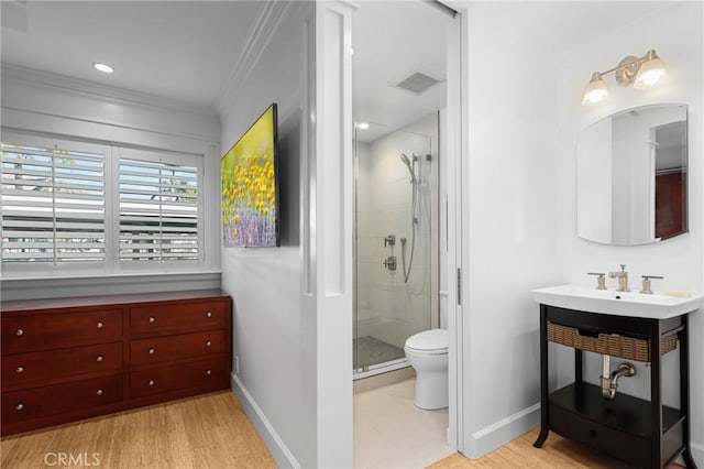 bathroom featuring baseboards, visible vents, toilet, crown molding, and a shower stall