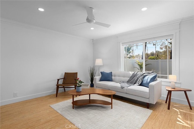 living room featuring light wood-type flooring, baseboards, and crown molding