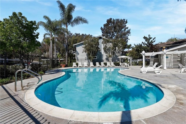 pool featuring a patio area, fence, and a pergola