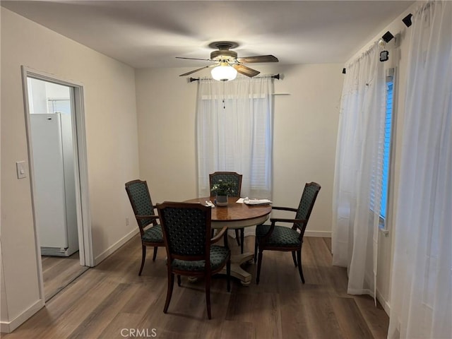 dining room with a ceiling fan, baseboards, and wood finished floors