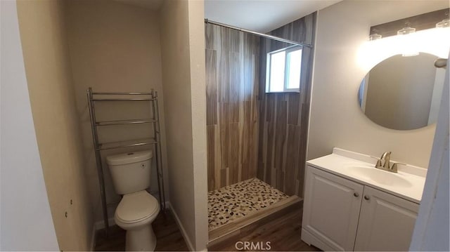 full bathroom with wood finished floors, a shower stall, toilet, and vanity