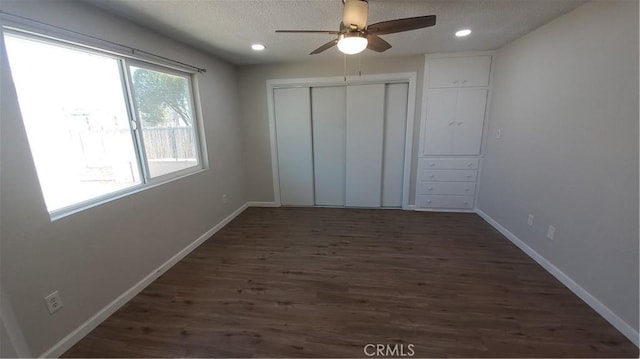 unfurnished bedroom with ceiling fan, recessed lighting, dark wood-type flooring, baseboards, and a closet