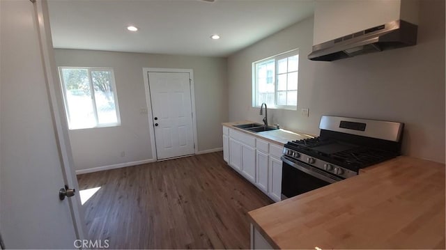 kitchen featuring under cabinet range hood, a sink, white cabinetry, wooden counters, and gas stove