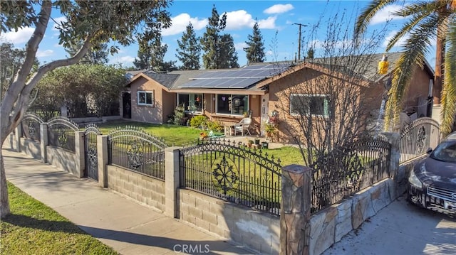 ranch-style home with a fenced front yard, roof mounted solar panels, a gate, and a front yard