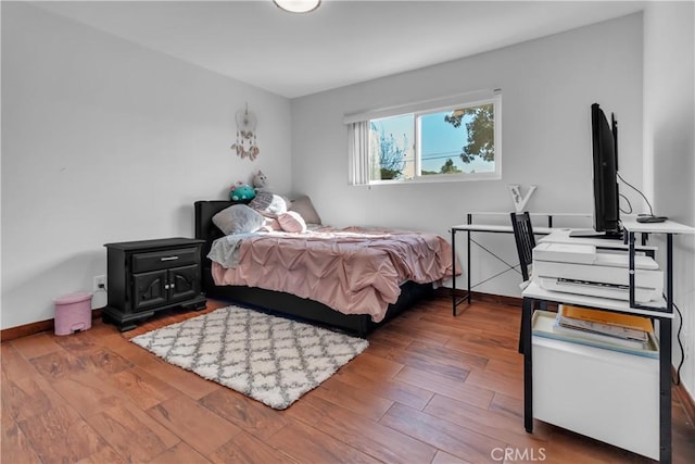 bedroom with baseboards and wood finished floors